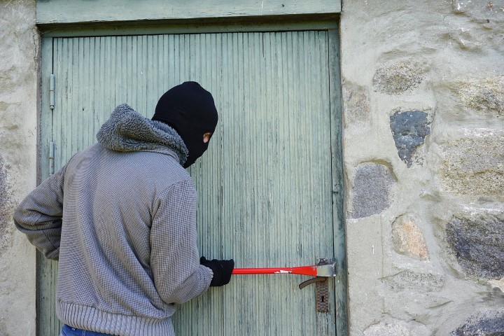 Hooded man attempting to steal private data